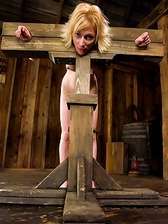 Blonde girl is restrained in a medieval stock